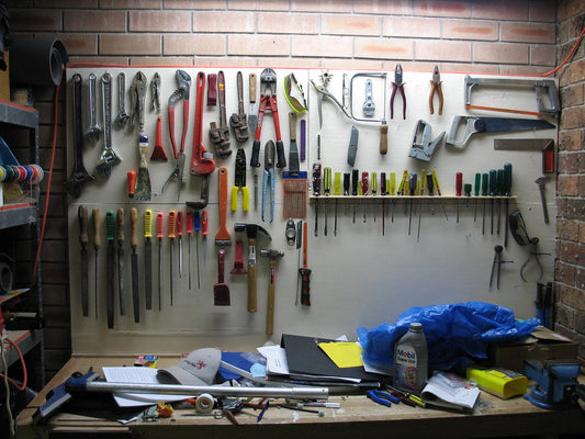 Home garage workbench with hand tools hanging on a pegboard wall
